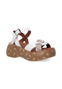 Weiße Wedge-Sandalen mit gekreuztem Riemendesign, ausgestattet mit einer gemusterten braunen Sohle und einer silbernen Schnalle. Strukturierter Oberteil und gepolsterte Innensohle.