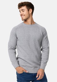 Maglione grigio a maglia con scollo rotondo, polsini e orlo a coste. La trama del tessuto è morbida, con un sottile motivo uniforme su tutta la superficie.