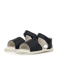 Sandali neri in pelle con design open-toe, due fasce larghe e una suola bianca texturizzata. Presentano fasce laterali regolabili con hardware.