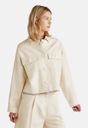 Gekürzte cremefarbene Jacke aus leichtem Stoff mit zwei vorderen Taschen, großen Knöpfen und einem Kragen. Glatte Textur.