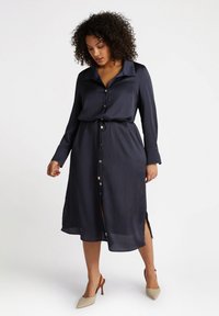 Navy striped shirt dress with long sleeves, button-down front, tie waist, and side slits. Features gold-tone buttons and a smooth fabric texture.