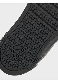 Suola di scarpa in gomma nera con un motivo circolare testurizzato, con il logo "adidas" visibile e l'etichetta "NON MARKING" impressa sul lato.