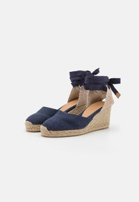 Námornícke plátené espadrilky s tkanou jutovou platformou. Obsahujú textúrovanú pätu a stuhy na členku pre bezpečné nosenie.