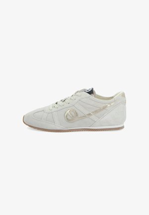Suède sneakers in lichtbeige met een gestructureerde afwerking, voorzien van een metallic gouden accentlogo en een zwarte treklus aan de hiel.