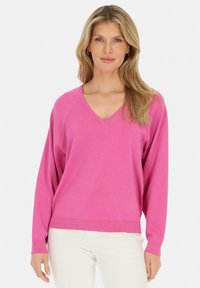 Sweter z dekoltem w serek, z długim rękawem w jaskrawym różowym kolorze, z prążkowanym wykończeniem na dole i przy mankietach; wykonany z miękkiego, gładkiego dzianiny.