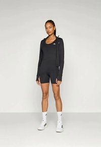 Svarte treningsdrakt med en tettsittende body og langermet jakke, med tre hvite striper på brystet og sokker for et koordinert utseende.