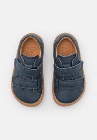 Zapatos de cuero azul marino con dos correas de Velcro y una suela de goma marrón, con punta redondeada y detalles de costura mínimos.