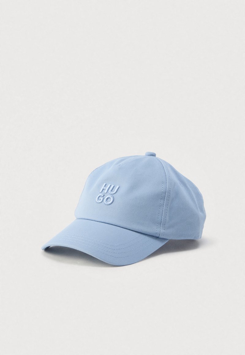 Light blue baseball cap made of cotton with an embroidered "HU GO" logo on the front and a curved visor. Soft texture and adjustable strap.