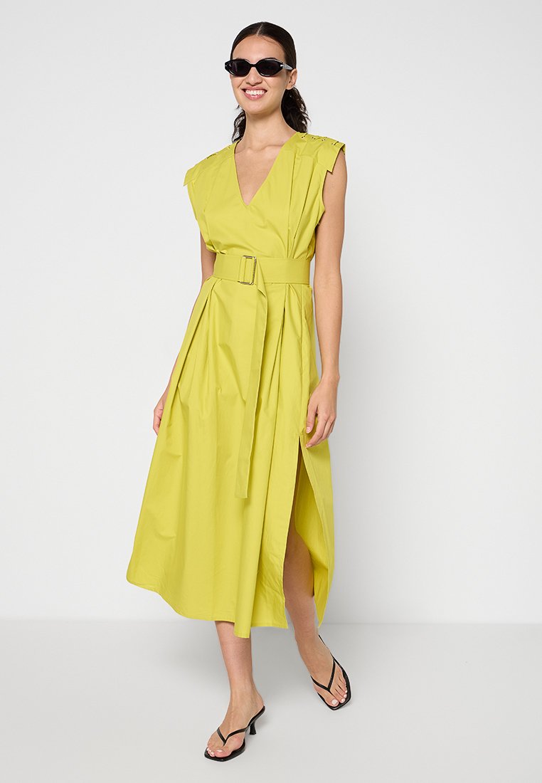 Gul midiklänning med bälte, kapprmar, djup V-ringning och sidoklyfta. Tillverkad av ett glatt tyg med en mjuk känsla och elegant fall.