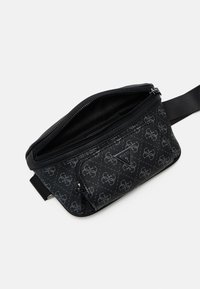 Black bag with a zip closure, featuring a diamond pattern with gray branding. Smooth leather material with a wide adjustable strap.