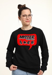 Felpa nera con una grande grafica di un fumetto rosso che mostra la parola "MISTER" e dei simboli. Realizzata in un materiale morbido con scollatura a girocollo.