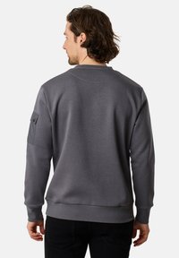 Felpa grigia con scollatura a girocollo, tessuto testurizzato e taschino sulla manica sinistra, con orlo e polsini a coste.