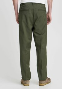 Pantalon vert olive à coupe droite, avec deux poches arrière et des passants de ceinture, présenté de dos avec une texture de tissu lisse.