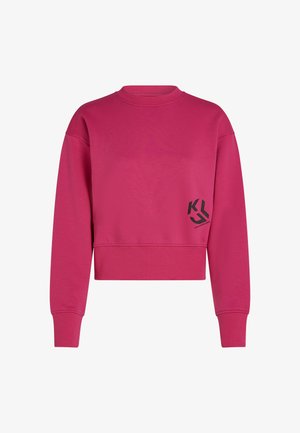 Fuksia kort sweatshirt med lange ermer, glatt tekstur og en svart logo på venstre front. Ribbestrikkede mansjetter og hals.
