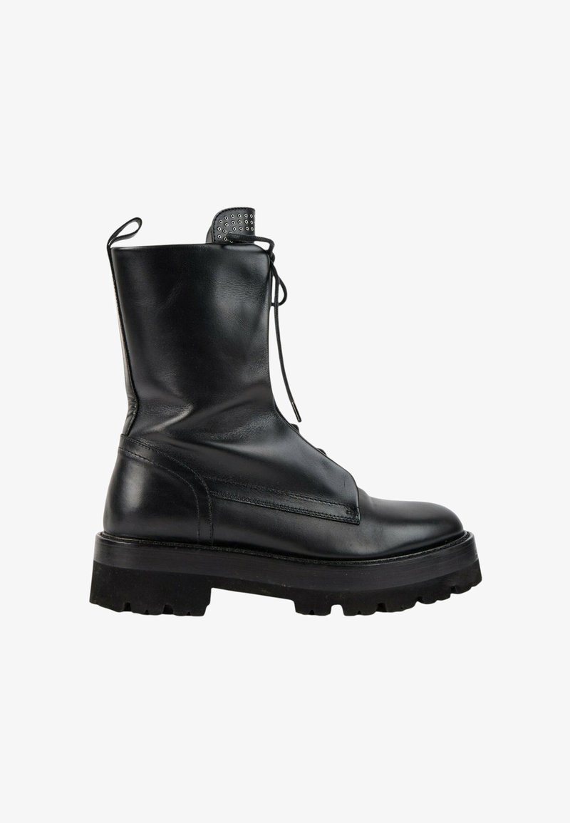 Botte de combat en cuir noir avec semelle épaisse en caoutchouc, laçage à l’avant, tige haute et languette à l’arrière, vue de côté.