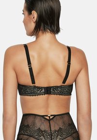 Zwart kanten beha met verstelbare bandjes en een haak-en-oogsluiting. Heeft een patroonontwerp en een zachte, gestructureerde stof.