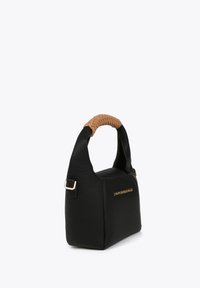 Black leather handbag with a structured shape, woven tan handle, and gold logo on the front, featuring a textured surface.