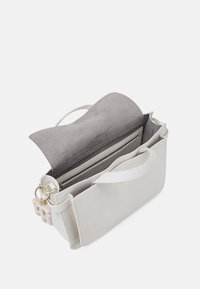 Borsa strutturata in pelle grigia chiara con una patta in suede grigio morbido. Presenta una tasca con zip e scomparti interni, oltre a dettagli in metallo dorato.