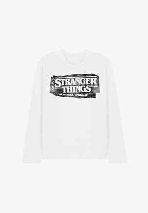 Weißes Langarm-T-Shirt mit einem schwarz, abgenutzten Grafikdruck des Textes "STRANGER THINGS" über der Brust.