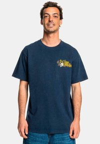 Navy blue cotton t-shirt featuring a front graphic of a skull and roses in yellow and red, with short sleeves and a relaxed fit.