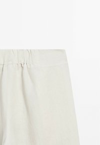Lichtbeige linnen broek met een elastische tailleband en een gladde, licht gestructureerde afwerking. Geen zichtbare patronen of accenten.
