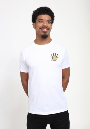 T-shirt blanc à manches courtes avec un motif de personnage de dessin animé sur le côté gauche de la poitrine. Fabriqué en coton avec une texture lisse.