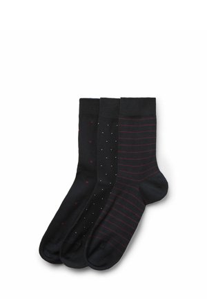 Drei Paar schwarze Socken mit unterschiedlichen Mustern: kleine rote Punkte, winzige weiße Quadrate und dünne rote horizontale Streifen.