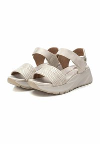 Sandalias de tacón bajo abiertas de color beige con tira delantera perforada, tira acolchada en el tobillo y suela tipo cuña acolchada para mayor comodidad y soporte.