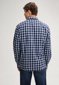 Camicia a maniche lunghe con bottoni, caratterizzata da un motivo a quadri blu e bianchi, realizzata in un tessuto leggero con colletto alla francese e polsini con bottone.