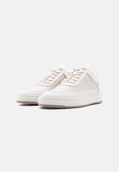 Ζευγάρι αθλητικά παπούτσια χαμηλού ύψους, εκρού χρώματος, με υφασμάτινες λεπτομέρειες, κλείσιμο με κορδόνια και παχιά λαστιχένια σόλα, σε απλό φόντο.