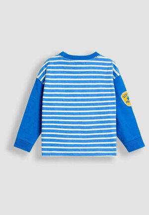 Sinine pika varrukaga särk, millel on valged horisontaalsed triibud ja sinine ühetooniline vars. Omab ümmargust kaelaauk ja kollast tikandiga plaastrit varrukal.