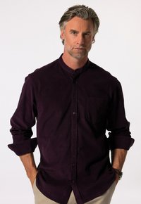 Camicia col collo di colore viola scuro con bottoni, maniche lunghe arrotolate, una tasca sul petto e una texture morbida. Design semplice, senza motivi.
