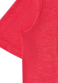 Gros plan sur le tissu d'une chemise rouge à manches courtes montrant la couture de la manche et le motif tricoté texturé.