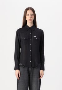 Black button-up shirt with a subtle ribbed texture, two chest pockets, silver buttons, and a brand tag on the left pocket.
