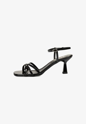 Sandalia negra de tiras con un diseño elegante, que presenta una puntera cuadrada y un tacón geométrico alto. Fabricada con un material brillante y con un acabado suave.