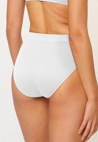Hochgeschlossene weiße Baumwollunterhose mit glatter Textur, weichem elastischem Bund und gewellten Beinöffnungen für Komfort und Passform.