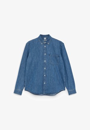 Blue denim long-sleeve shirt with a pointed collar, white buttons, single chest pocket, and a straight hem. Even texture and medium weight.
