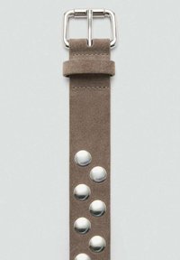 Rjav semiš pas z srebrnimi zakovicami in pravokotno kovinsko zaponko na vrhu. Pas ima gladko teksturo in čiste linije.