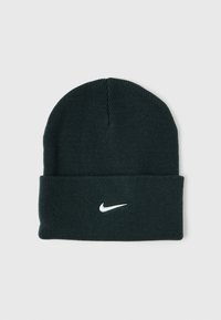 Tamnozelena pletena kapa s preklopom i bijelim logotipom Nike. Izrađena od mekog, rastezljivog materijala, s bešavnom vrhom.