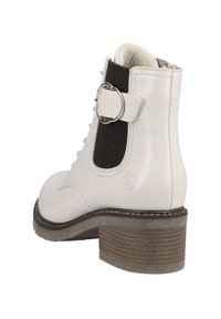 Bottine en cuir blanc avec un panneau élastique noir, fermeture à lacets à l'avant, accent de bague décoratif et talon en bois moyen. Fini texturé.