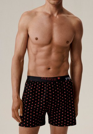 Czarne bokserki z czerwonym wzorem serc, elastycznym pasem oznaczonym "ATLANTIC", o luźnym kroju i miękkiej fakturze materiału.