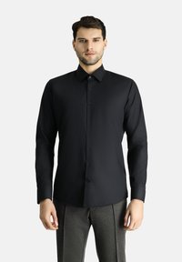 Camicia nera a maniche lunghe con bottoni, caratterizzata da un design elegante, una texture liscia, colletto standard e chiusura frontale con bottoni.