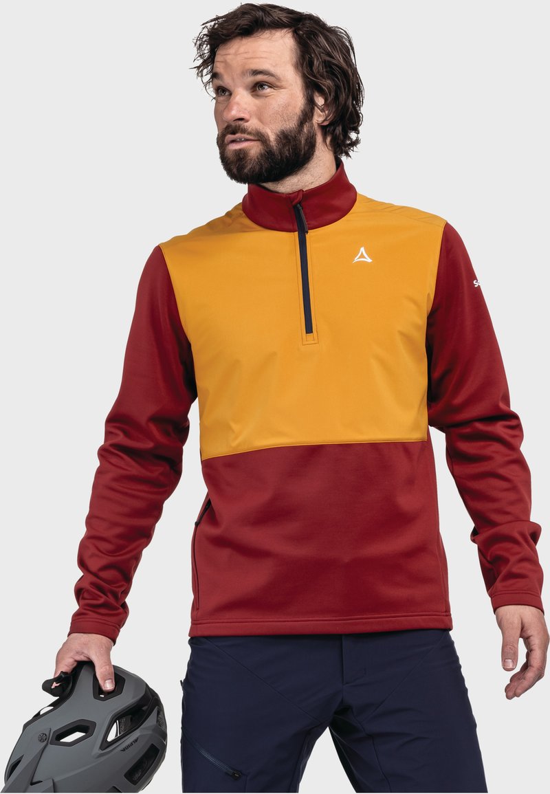 Langärmliger Pullover aus orange-rotem Stoff mit hohem Kragen, halbem Reißverschluss und Logo auf der Brust. Glatte Textur, sportliches Design.
