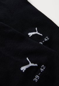Juodi kojinės su minkšta tekstūra, su balta Puma logo ir dydžio žyme (39-42) medžiagoje. Paprastas dizainas ir spalva.
