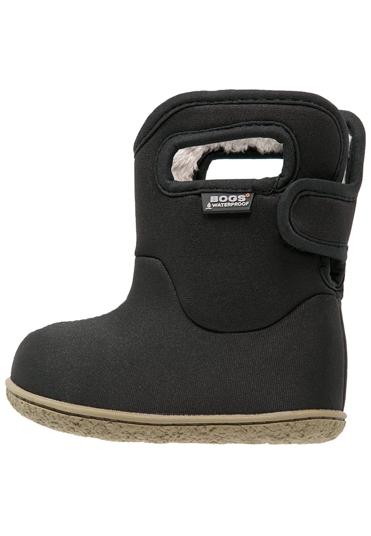 Bota negra impermeable con forro de suave pelo, suela de goma y cierre de velcro. Presenta un asa recortada en el costado.