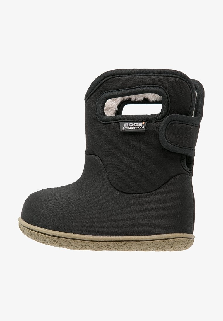 Bota negra impermeable con forro de suave pelo, suela de goma y cierre de velcro. Presenta un asa recortada en el costado.