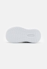 Semelle de sneaker blanche avec un motif en caoutchouc texturé, présentant un logo Adidas au niveau de la semelle intermédiaire et des rainures d'adhérence subtiles pour une meilleure traction.