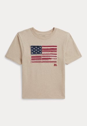 T-shirt beige à manches courtes avec un patch tricoté du drapeau américain et des initiales rouges "RL" au centre avant.