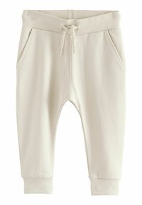 Pantalons de survêtement beige avec une taille et des poignets côtelés, dotés d'un cordon de serrage et de deux poches latérales. Texture lisse et design décontracté.