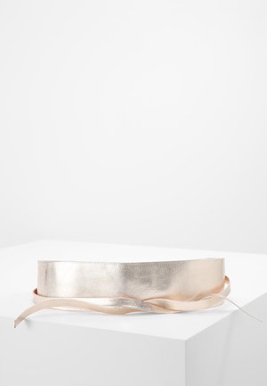 Szeroki pasek w kolorze metalicznego różowego złota z długimi, cienkimi paskami, pokazany na płasko na białym tle.